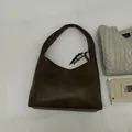 Vue détaillée du grand sac hobo en cuir marron avec perle colorée sur tissu blanc - Avec Pendentif / Marron