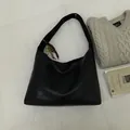 Sac seau minimaliste en cuir noir avec pendentif en bois et logo métallique en détail - Avec Pendentif / Marron