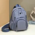 Light lavender-grey waterproof nylon backpack with multi-pocket storage and silver M badge - Blue