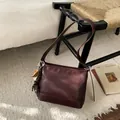 Détail du sac à épaule bordeaux en cuir avec breloque de baseball et pompon à franges - Avec Pendentif / Bordeaux