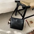 Détail du sac à main en cuir noir sur une chaise en bois avec charme de baseball - Avec Pendentif / Noir