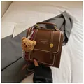 Sac à dos en cuir marron foncé vintage avec surpiqûres blanches et charme d'ours peluche - Marron avec Pendentif