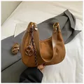 Borsa a mezzaluna in camoscio marrone con dettagli dorati e ciondolo intrecciato - Con Ciondolo / Marrone