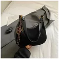 Borsa sottobraccio nera opaca con finiture lucide e ciondolo intrecciato marrone - Con Ciondolo / Nero