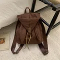 Detalle de mochila marrón oscuro con orejas de conejo en gamuza y cierre de cordón - Café