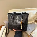 Große schwarze geprägte Leder-Tote-Bag mit Cartoon-Muster und Holzperlen-Anhänger - Schwarz