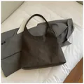 Minimalist dark grey suede tote bag with wide shoulder strap on grey blazer background - No Pendant / Brown