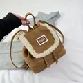 Detail of brown suede mini backpack featuring faux shearling trim and cute bear patch - Brown