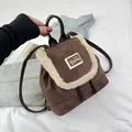 Close-up of a brown mini drawstring backpack with white fleece trim and bear patch detail - Brown
