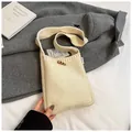 Cream knit crossbody bag with wooden toggle button on a soft white background - Off White