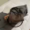 Dunkelbraune Canvas-Leder-Tasche mit Teddybär-Anhänger auf grauem Blazer - Klein (Mit Anhänger) / Braun