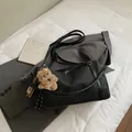 Minimalistische schwarze Tragetasche mit Teddybär-Anhänger auf grauem Anzug - Groß (Mit Anhänger) / Schwarz