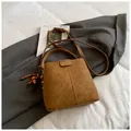 Borsa a secchiello marrone in finta pelle con ciondolo in legno e tracolla regolabile - Marrone