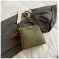 Borsa a secchiello verde oliva in pelle opaca con perline in legno e tracolla larga - Verde