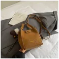 Braune Beuteltasche aus mattem Leder mit weißem Pelzanhänger und Schultergurt - Mit Anhänger / Braun