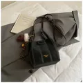 Minimalistische schwarze Beuteltasche mit Kontrastnähten und goldenem Logo-Detail - Mit Anhänger / Schwarz