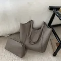 Vista detallada del gran bolso tote taupe con estuche a juego y textura de cuero granulado - Juego de Bolso Tote / Gris