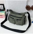 Détail du sac bandoulière en nylon vert kaki avec multi-poches et zips à anneaux ronds - Vert