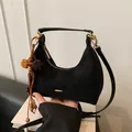 Black suede crescent shoulder bag featuring gold hardware and vintage tassel charm - Black With Pendant