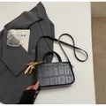 Schwarze Bucket Bag mit Kroko-Prägung, Perlenanhänger und goldenem Logo-Schriftzug - Mit Anhänger / Schwarz