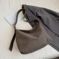 Dark coffee PU leather tote bag with wide shoulder strap on a grey blazer background - Green Without Hanger