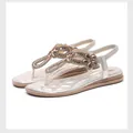 Detail of champagne gold flat sandals featuring rhinestone flower patterns and elastic straps - EU 35 / Light gold