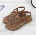 Detail of bohemian flat sandals with decorative 3D flowers, beads and ethnic patterns - EU 36 / Brown