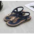 Detail of navy blue flip flop sandal with gold buckle and woven strap on marble surface - EU 36 / Blue