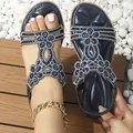 Détail de sandales bohèmes bleues avec strass et motif floral sur fond en bois - 38 / Bleu foncé