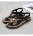 Detail of black thong sandals featuring gold U-shaped buckles and woven strap texture - EU 36 / Black