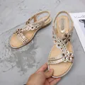Women's gold flat Bohemian sandals featuring rhinestone flower straps and elastic heel - 35 / Gold