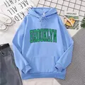 Detail of light blue hoodie featuring green Brooklyn typography and ribbed cuffs - Sky Blue