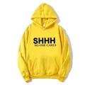 Detail view of bold 'SHHH' slogan print on a bright yellow cotton hoodie with kangaroo pocket - Yellow