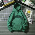 Detail of dark green hoodie with Los Angeles print and kangaroo pocket on urban background - Dark Green