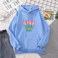 Flat lay of light blue oversized hoodie featuring pink tulip graphic and kangaroo pocket - Sky Blue