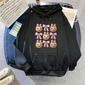 Detail of black hoodie featuring pumpkin and bow prints with a kangaroo pocket and drawstrings - S / Black