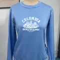 Close-up of the vintage Columbia print and white graphic on the blue crewneck sweatshirt - S / Sky Blue
