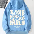 Light blue fleece hooded sweatshirt for women featuring white LOVE NEVER FAILS print - S / Sky Blue