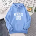 Dettaglio felpa con cappuccio oversize azzurra con scritta Newport 1984 Beach e tasca - M / Celeste