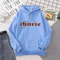 Détail du sweat à capuche bleu clair oversize avec texte gothique noir et orange - S / Bleu ciel