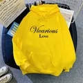 Detail of a bright yellow hoodie featuring black Vicarious Love text and kangaroo pocket - S / Yellow