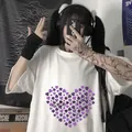 Detail eines weißen Oversize-T-Shirts mit lila Herz-Klee-Print und schwarzer Aufschrift - S / Weiß