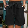Casual black high-waist shorts with a drawstring bow and a single amber button detail - S / Black