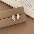 Elegant silver triple flower earrings with brushed metal texture on jewelry stand - Silver Triple Five Petal Flower