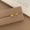 Minimalist golden cat-shaped stud earrings shown in a cute walking and stretching pose - Golden Brushed Cat Earrings