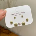 Three pairs of matte gold ball earrings in different sizes on a white display card - Round Set / Gold