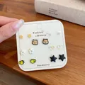 Set di 7 paia di orecchini con animali e fiori su cartoncino bianco espositivo - Stile Anatroccolo Giallo e Capibara (HMS6)