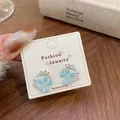 Orecchini a fiori blu con perle bianche e scintillanti pietre di zirconia cubica - Fiore Blu Luccicante