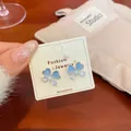 Elegant butterfly stud earrings with light blue heart stones on a display card - Blue Butterfly Cat Eye Stone Style (NV3)
