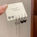 Silver-toned earring set with black heart, bow, and butterfly charms on jewelry card - Black Butterfly Style